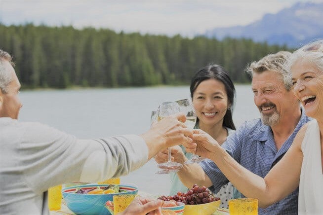 elderly-friends-and-family-laughing-over-meal-with-wine